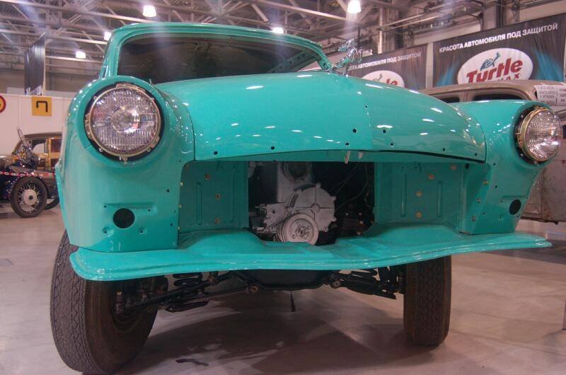 Oldtimer 06 2: бирюзовый ретро-автомобиль с открытым моторным отсеком в выставочном зале