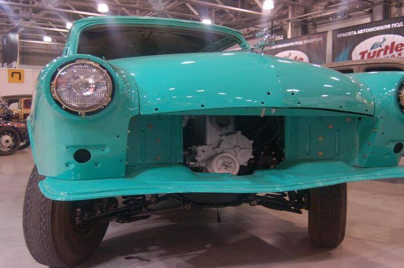 Oldtimer 06 2: бирюзовый ретро-автомобиль с открытым моторным отсеком в выставочном зале