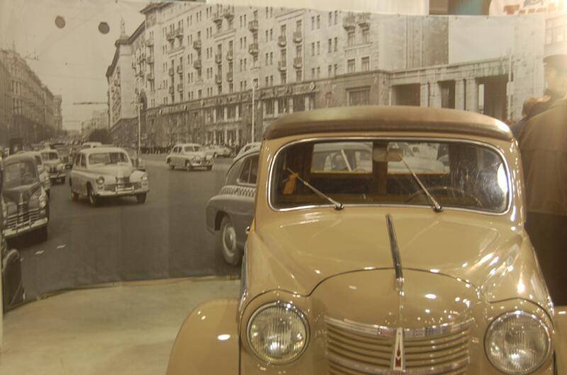 Oldtimer 06 2: бежевый «Москвич» перед панорамой улицы с советской застройкой