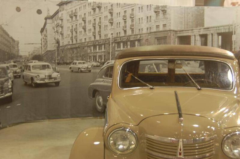 Oldtimer 06 2: бежевый «Москвич» перед панорамой улицы с советской застройкой