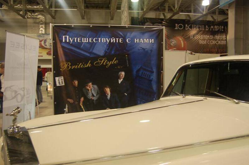 Oldtimer 06 2: белый ретро-автомобиль у баннера «Путешествуйте с нами»