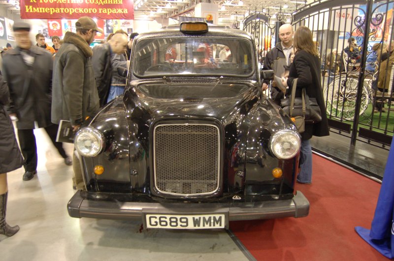 Oldtimer 2007: чёрный такси-такси в зале выставки с надписью «К 100-летию создания Императорского гаража»