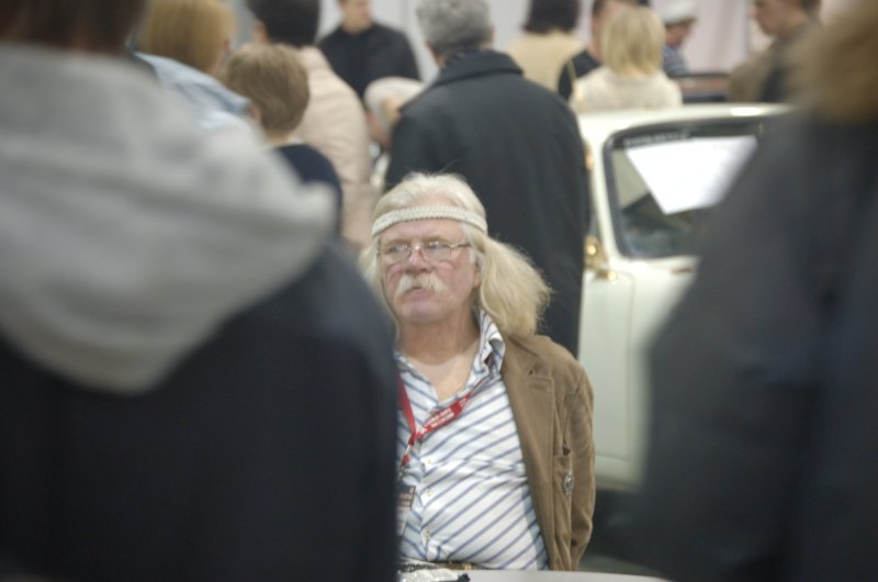 Oldtimer 2007: мужчина с бахромой на голове и полосатой рубашке среди белого авто
