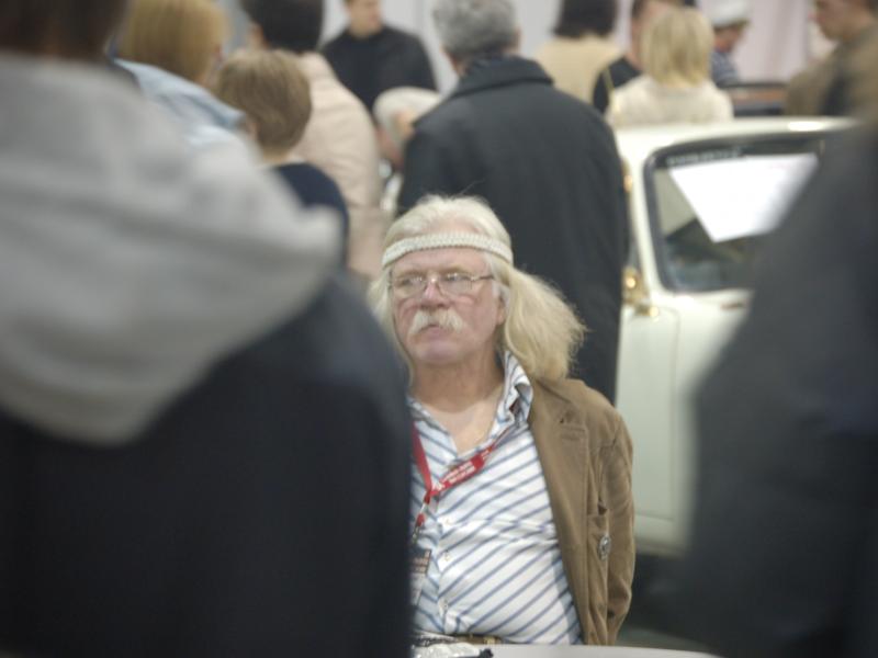 Oldtimer 2007: мужчина с бахромой на голове и полосатой рубашке среди белого авто