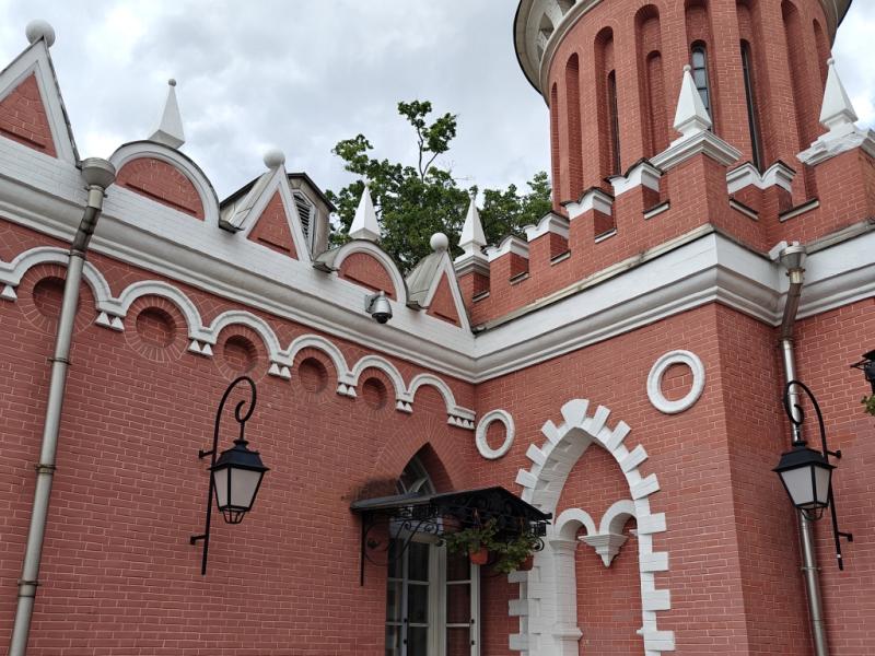 Петровский путевой дворец: красно-белая башня с арочным входом и фонарями