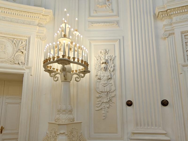 Внутри Петровского путевого дворца: белый канделябр и рельеф рыцаря