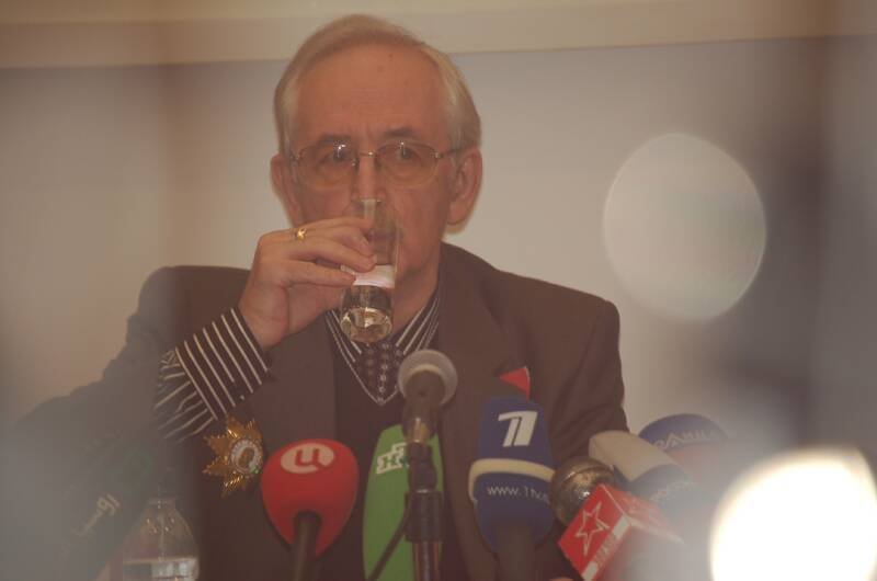 Памятник Шерлоку Холмсу в России: мужчина за столом с микрофонами