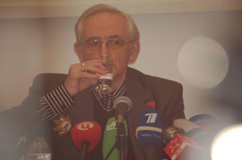 Памятник Шерлоку Холмсу в России: мужчина за столом с микрофонами