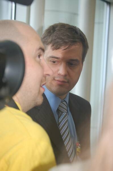 Памятник Шерлоку Холмсу в России: мужчина в костюме с галстуком и другой в желтой рубашке у окна