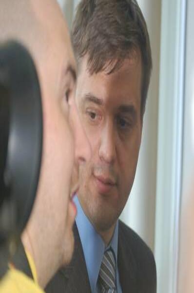Памятник Шерлоку Холмсу в России: мужчина в костюме с галстуком и другой в желтой рубашке у окна