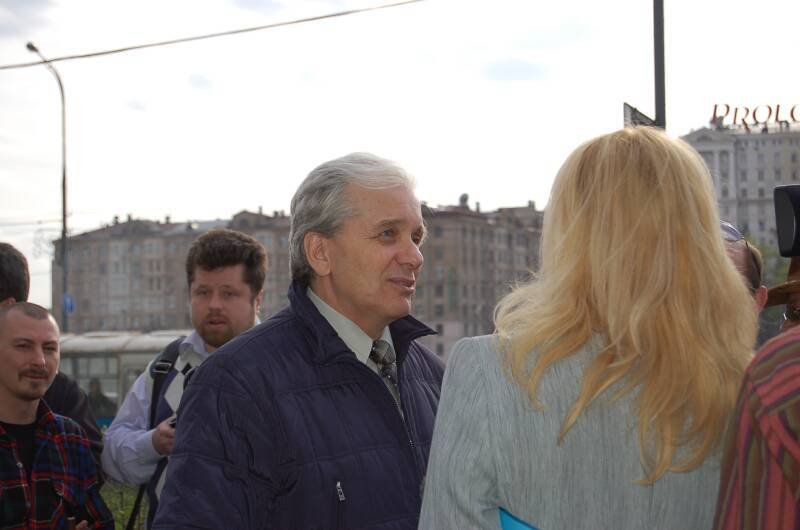 Памятник Шерлоку Холмсу в Санкт-Петербурге: серый день, люди и «PROLOG» на фоне