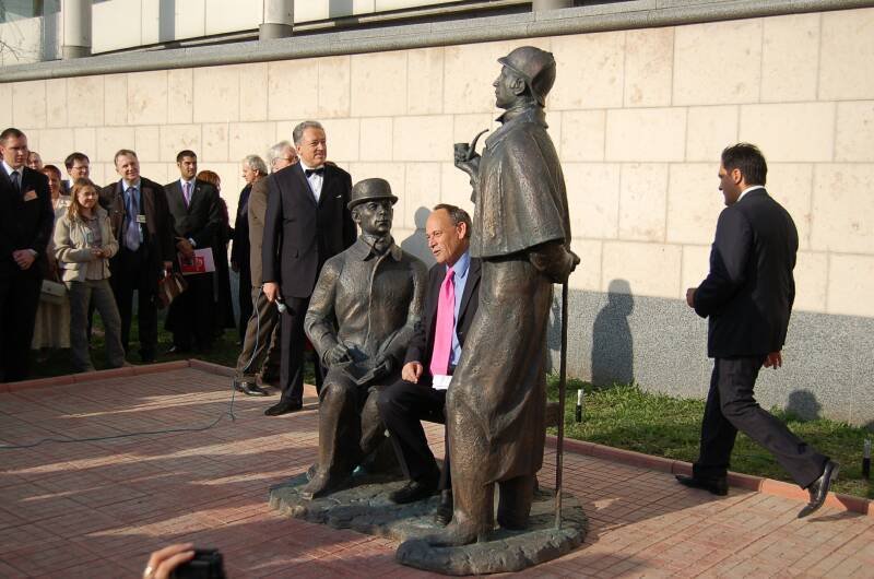 Памятник Шерлоку Холмсу в Москве: бронзовые фигуры у стены из светлого камня
