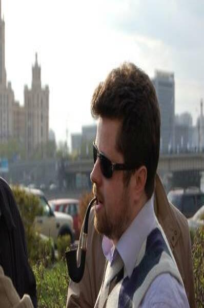 Памятник Шерлоку Холмсу в Москве: мужчина с трубкой у зелёной изгороди