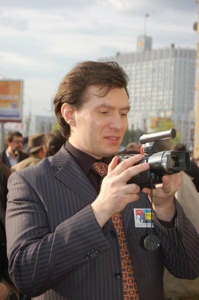 Памятник Шерлоку Холмсу в Москве: мужчина с видеокамерой у здания в стиле позднесоветской типовой застройки