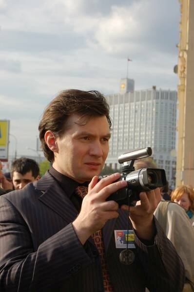 Памятник Шерлоку Холмсу в Москве: мужчина с видеокамерой у здания с флагом