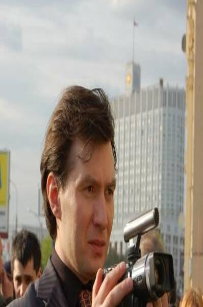 Памятник Шерлоку Холмсу в Москве: мужчина с видеокамерой у здания с флагом