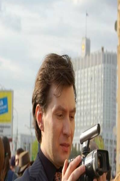 Мужчина в пиджаке с видеокамерой на улице города