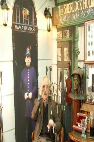 Памятник Шерлоку Холмсу в Москве: мужчина в кресле у вывески «The Sherlock Holmes»
