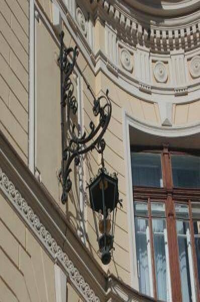 Фонарь на углу здания в СПб: кованая ручка и лепнина барокко