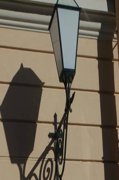 Уличный фонарь на фасаде в Spb Flashlamps: кованая подставка и тень от лампы