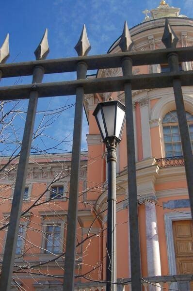 Оранжевый фасад с куполом за решеткой в СПб