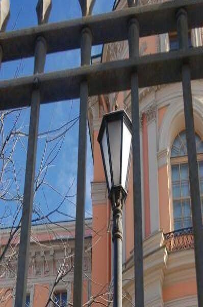 Оранжевый фасад с куполом за решеткой в СПб