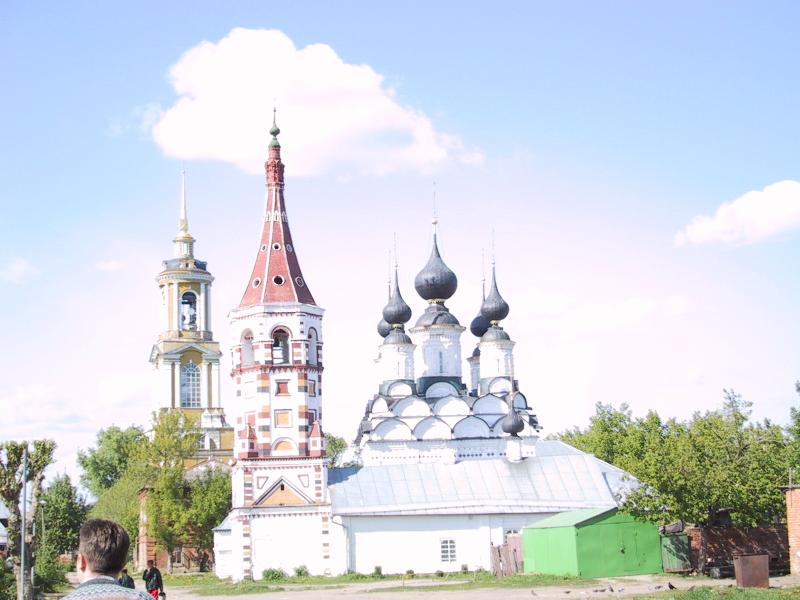 Суздаль, май 2002: колокольня с красно-белой шатровой крышей и церковь с чёрными куполами