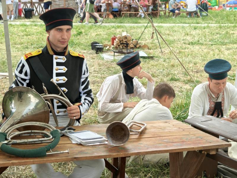 Times And Epochs 2026: мушкетёр с французской роговой трубой у деревянного стола