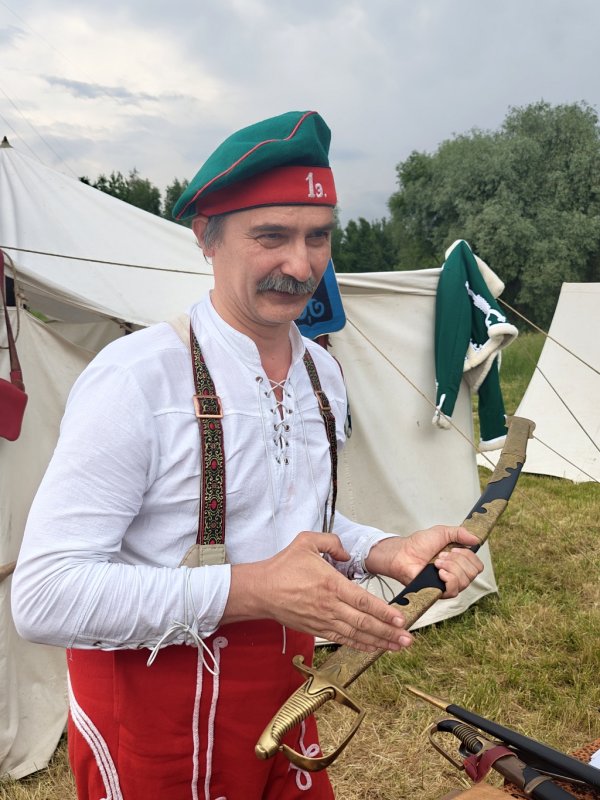 Times And Epochs 2026: мужчина в историческом костюме с саблей у палаток
