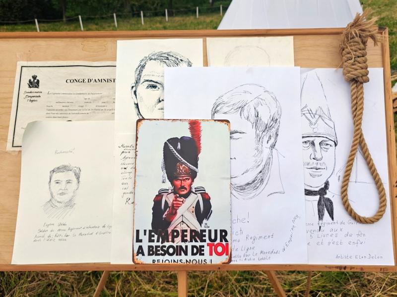 Times And Epochs, 2026: деревянный стенд с рисунками, документом и плакатом «L'EMPEREUR A BESOIN DE TOI»