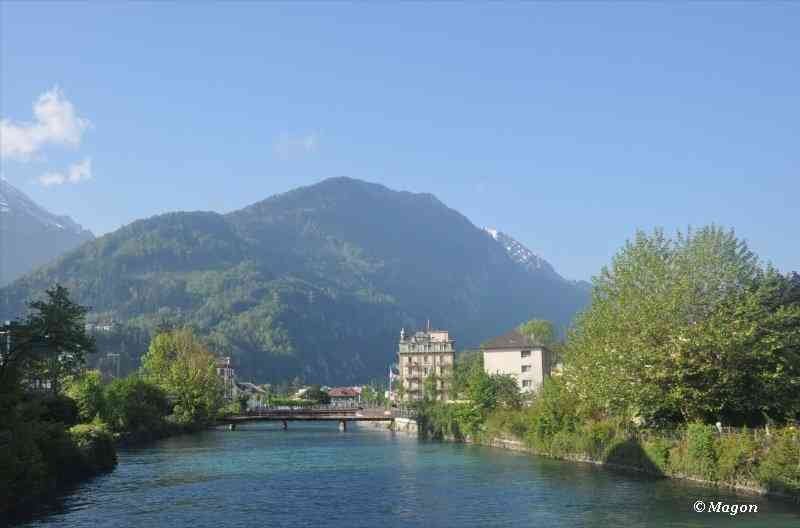 Река в Швейцарии у подножия гор, мост и старинные дома