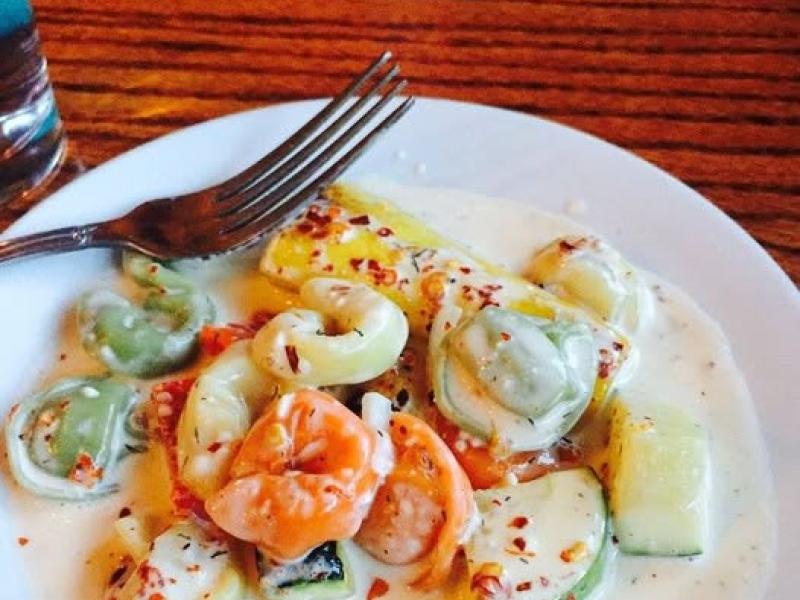 Pasta Freska, США: тортеллини с креветками в кремовом соусе на деревянном столе