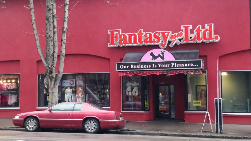 Красное здание магазина Fantasy Ltd с красным автомобилем